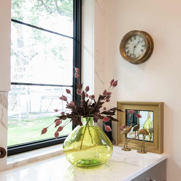 Newman Home on Lake Eunice, MN • green clear glass vase with flowers on kitchen counter