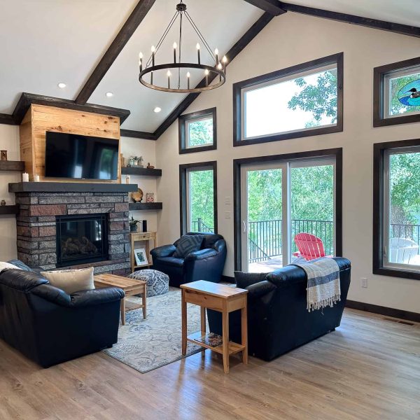 Schaefbauer home on Munson Lake living room with fireplace and lakeside patio doors view #2 • zoom out