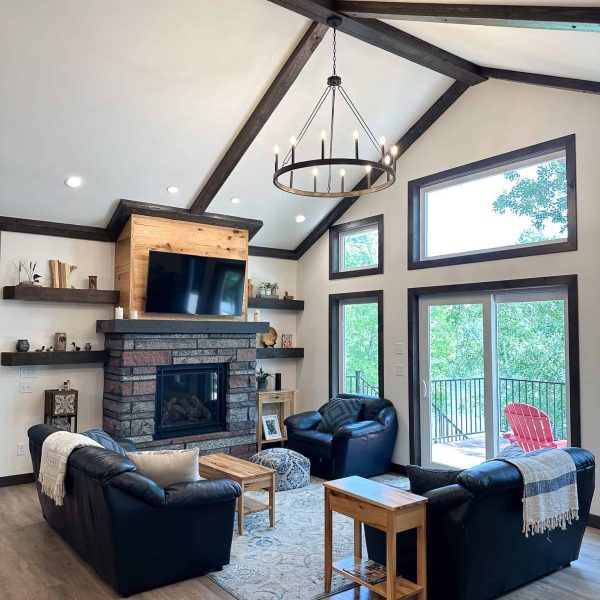 Schaefbauer home on Munson Lake living room with fireplace and lakeside patio doors • full room scene