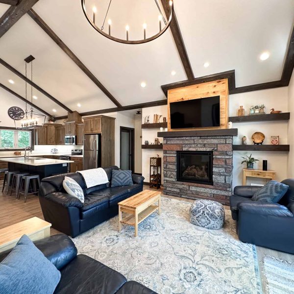 Schaefbauer home on Munson Lake living room with fireplace, view into the kitchen