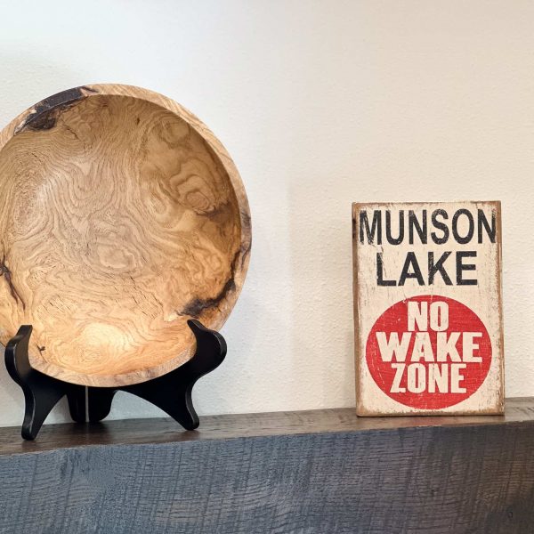 Schaefbauer home on Munson Lake living room shelf with decorative wood bowl and sign stating, "Munson Lake, No Wake Zone."