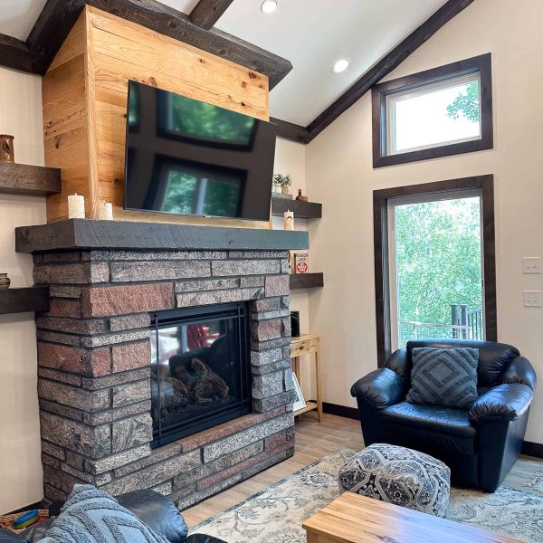 Schaefbauer home on Munson Lake living room fireplace and corner window and leather chair