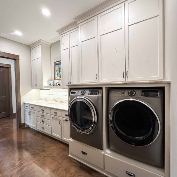 Spicer Home on Pelican Lake • Laundry room with washer and dryer built into cream-colored cabinets