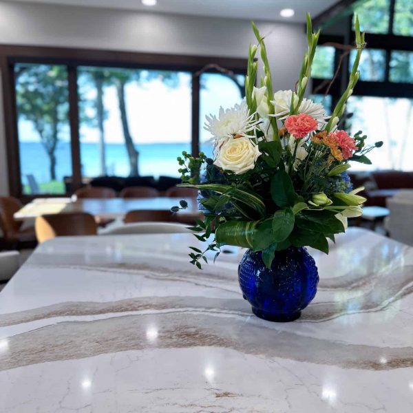 Spicer Home on Pelican Lake marble island countertop with flowers with the view of the lake through the dining room window