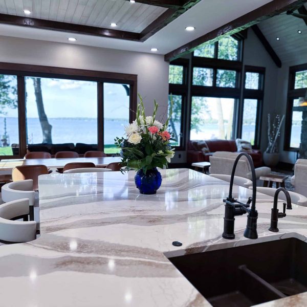 Spicer Home on Pelican Lake marble island countertop with flowers with the view of the lake through the dining room window