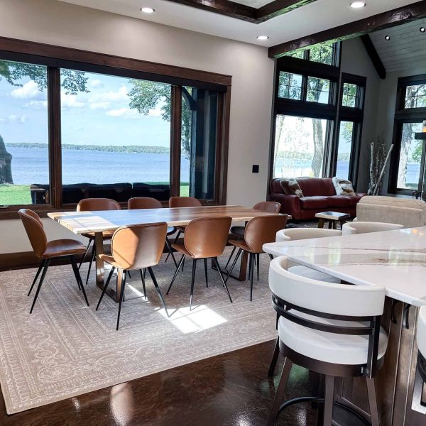 Spicer Home on Pelican Lake • wood dining room table with view of the lake through a large picture window