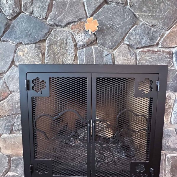 Spicer Home on Pelican Lake • Living room fireplace with clover cutout shapes in the metal of the fireplace doors