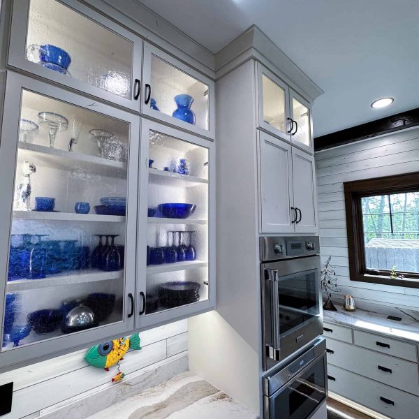 Spicer Home on Pelican Lake • blue dishes in cabinets with glass doors, next to the oven