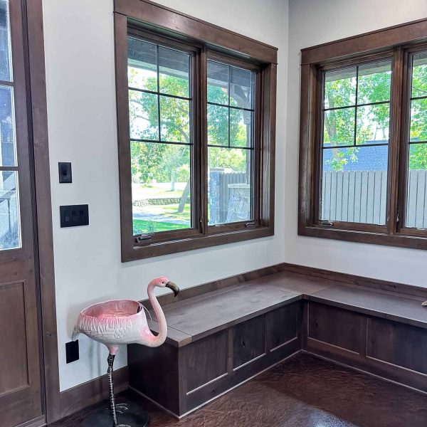 Spicer Home on Pelican Lake • roadside door with flamingo statue next to a wooden built-in bench