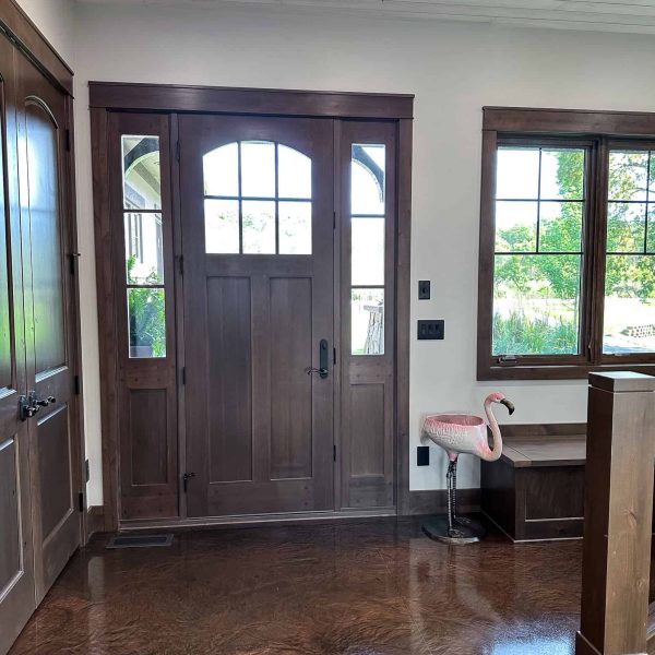 Spicer Home on Pelican Lake • roadside door with flamingo statue next to a wooden built-in bench