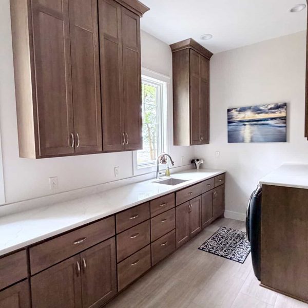Contemporary kitchen with wooden cabinets and white countertop.