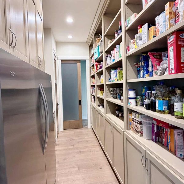 Organized pantry with shelves filled with food and kitchen supplies.