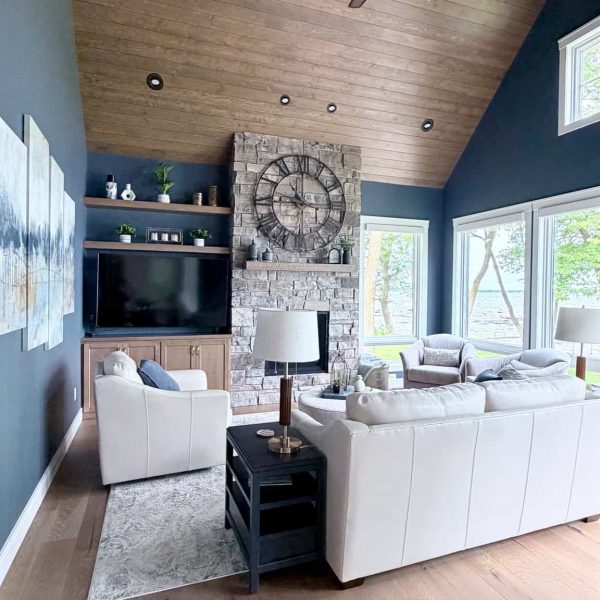 Spacious living room with vaulted wooden ceiling and large windows.