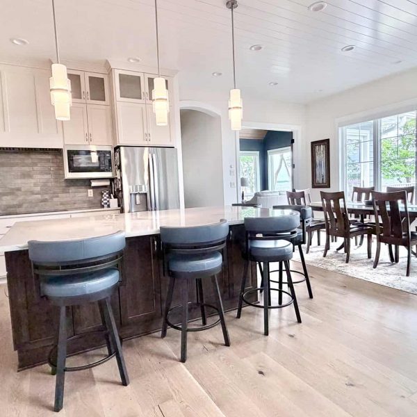 Bright modern kitchen with island and dining table with large windows.