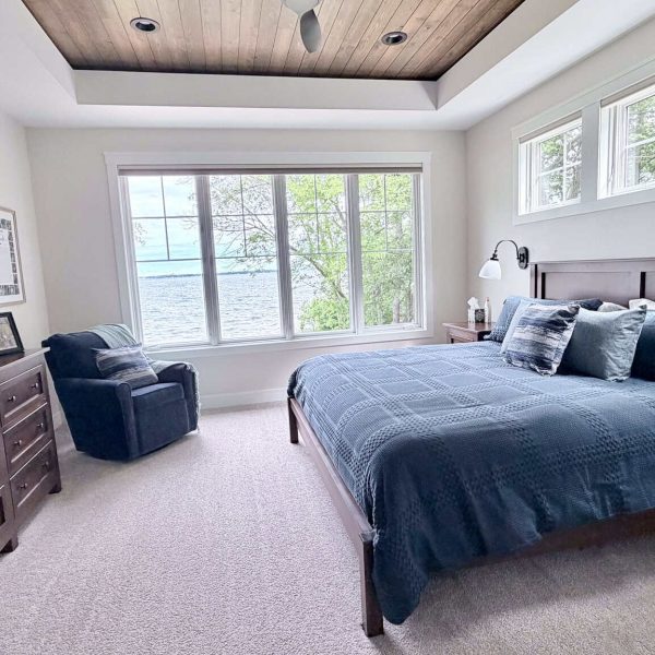 Spacious bedroom with large windows overlooking Detroit Lake.