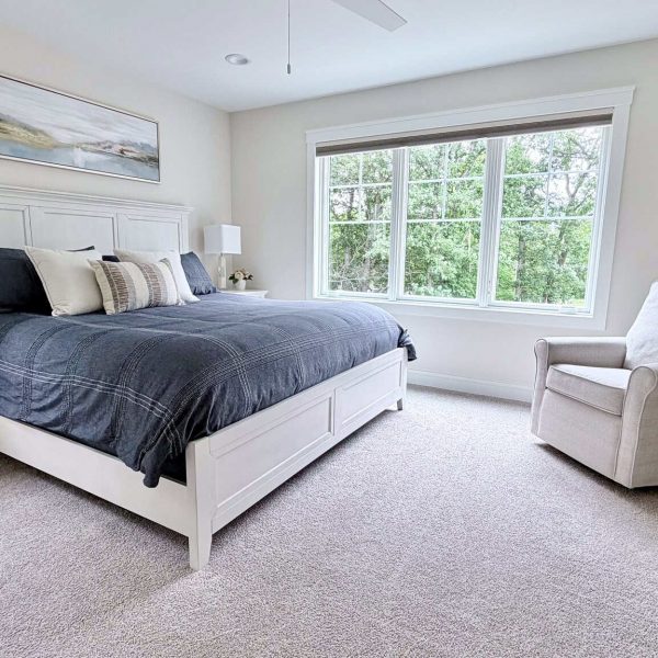 Bright and spacious bedroom with large window and minimalist decor.