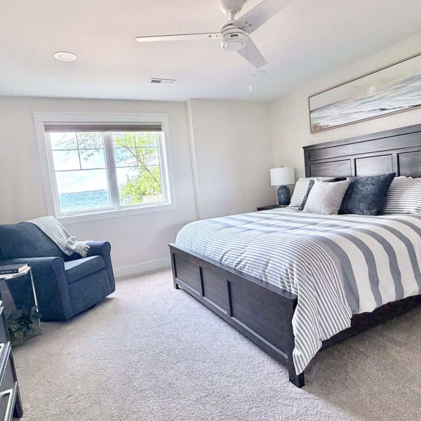 Spacious bedroom with large bed, navy blue accents, and natural light from window.