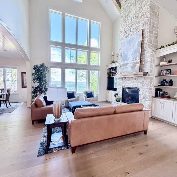 Spacious living room with high ceilings, large windows, and modern decor.