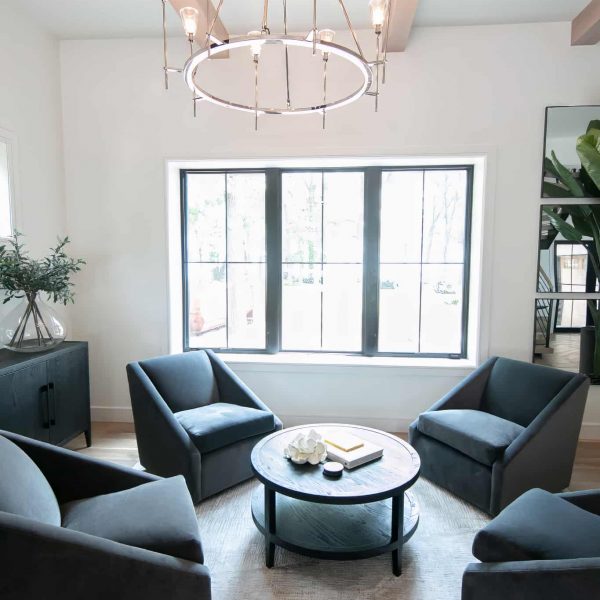 Zunich Home on Detroit Lake living room fireplace sitting area with chandelier and view to the backyard through the window